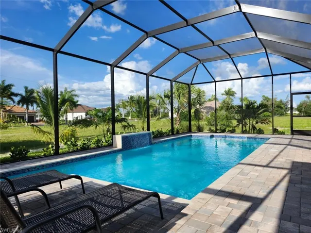 View of swimming pool with a patio area and glass enclosure