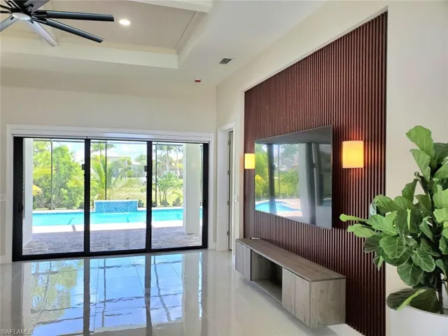 Doorway with tile patterned flooring and ceiling fan