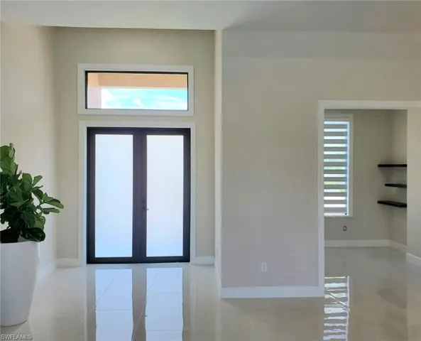 Tiled entrance foyer featuring french doors