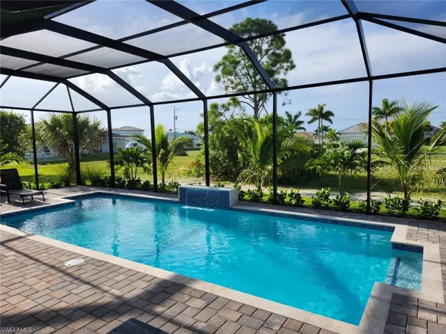 View of pool featuring pool water feature, a patio area, and a lanai