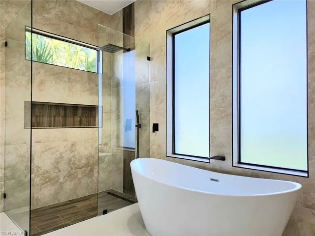 Bathroom with tile walls and independent shower and bath