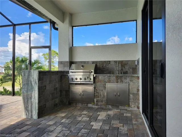 View of patio / terrace featuring a lanai, area for grilling, and a grill