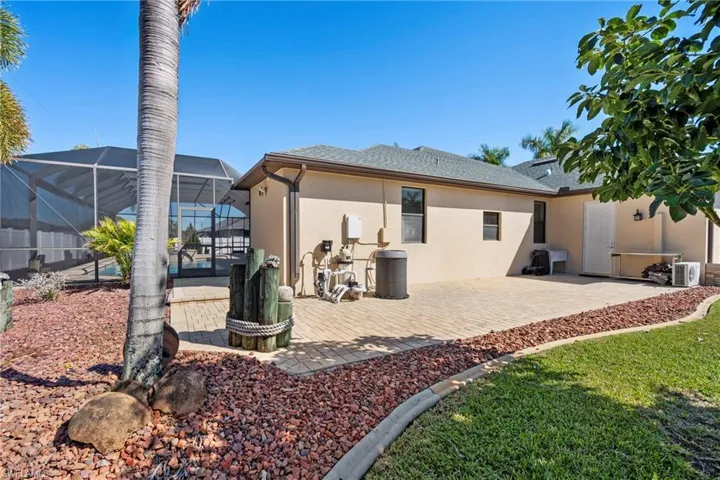 Rear view of property with a lanai, stucco siding, a patio, a sunroom, and a shingled roof