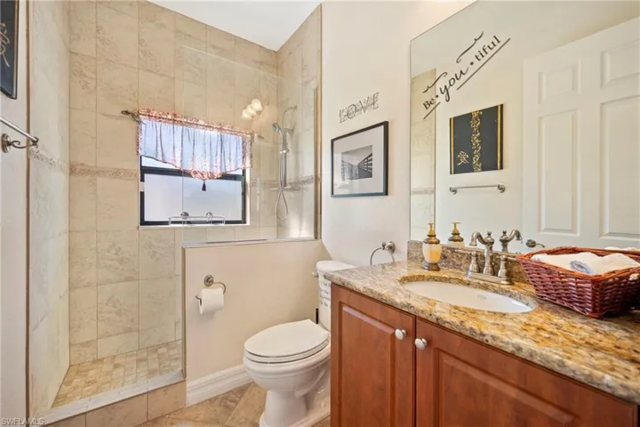 Full bath featuring vanity and tiled shower