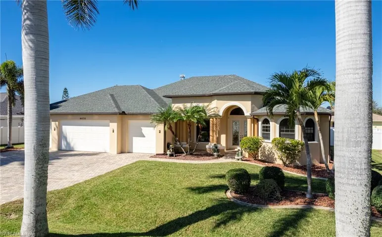 View of front facade with an attached garage, decorative driveway, stucco siding, roof with shingles, and a front yard