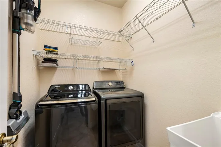 Laundry room with a textured wall and washing machine and dryer