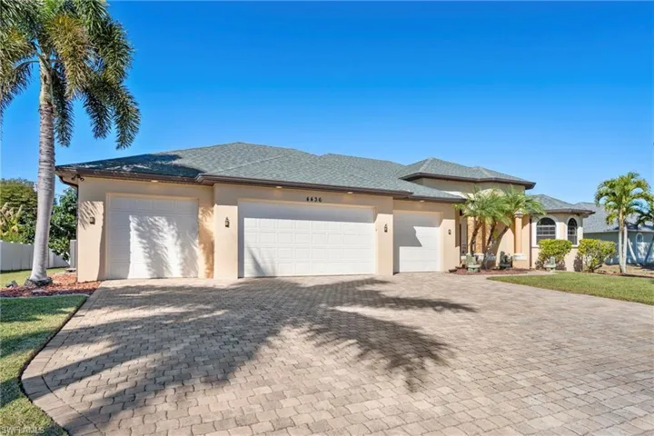 View of front of home with a garage, driveway, stucco siding, and roof with shingles