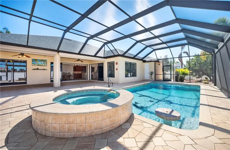 Integrated pool / hot tub with a patio area, a sunroom, and a lanai
