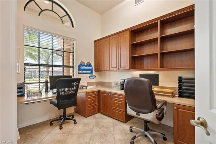 Office area with built in desk and light tile patterned floors
