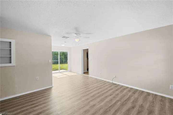 Livingroom / dining area featuring wood finished floors, ceiling fan, and a textured ceiling