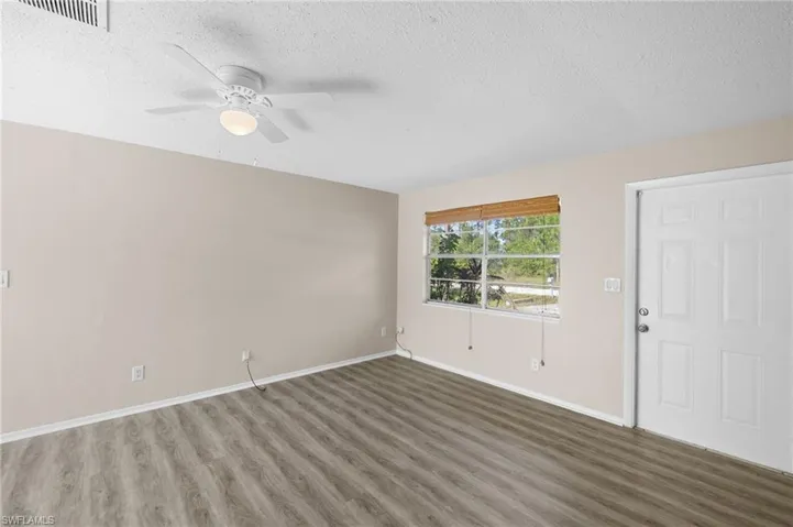 Livingroom featuring wood finished floors, ceiling fan, and a textured ceiling