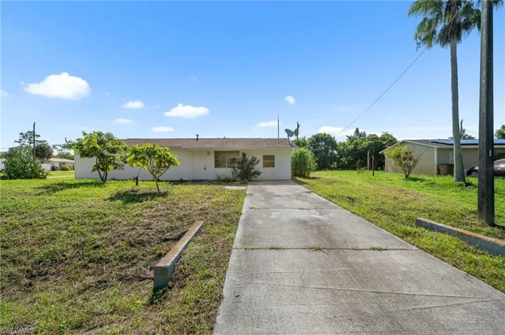 Single story home featuring driveway and a front lawn
