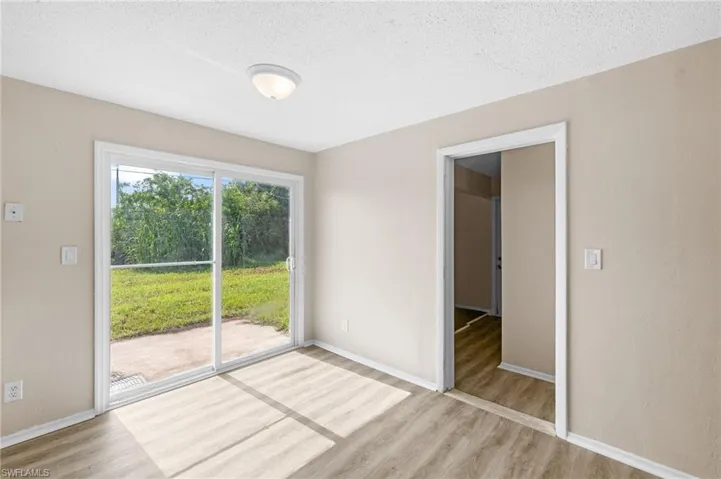 dining area with light wood-style flooring and a textured ceiling