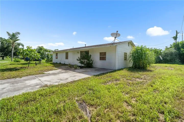 View of front of house featuring concrete driveway and a front lawn