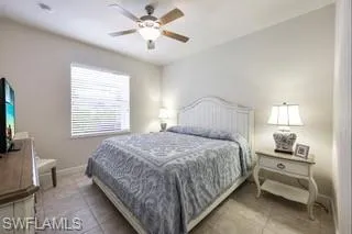 Bedroom featuring light tile patterned floors and ceiling fan