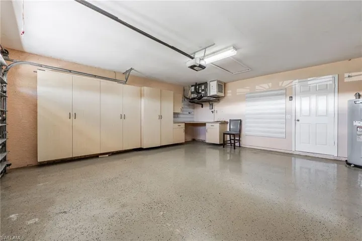 Garage featuring water heater and a garage door opener