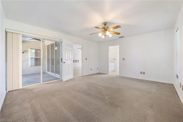 Unfurnished room featuring carpet flooring, ceiling fan, and attic access