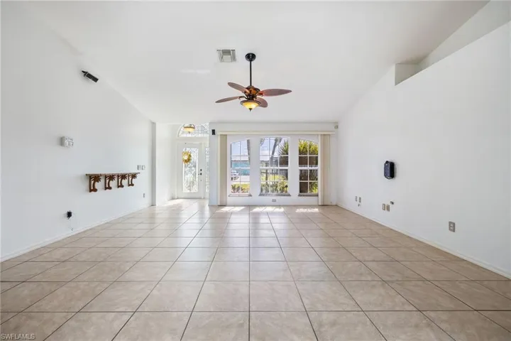Unfurnished living room with light tile patterned flooring and a ceiling fan