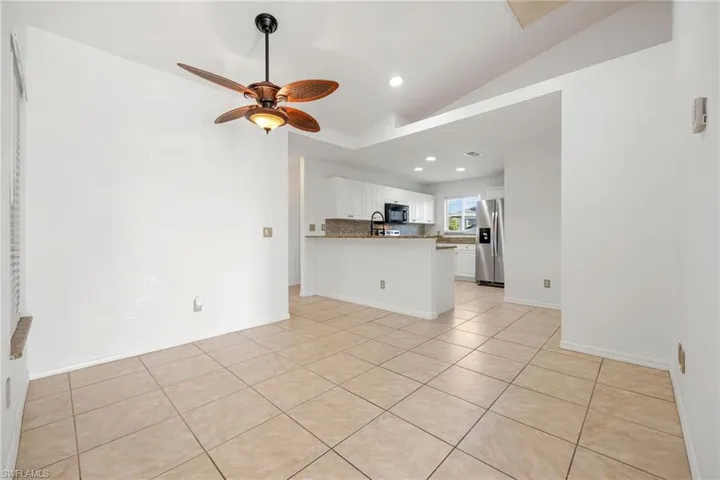 Unfurnished living room with light tile patterned floors, recessed lighting, vaulted ceiling, and ceiling fan