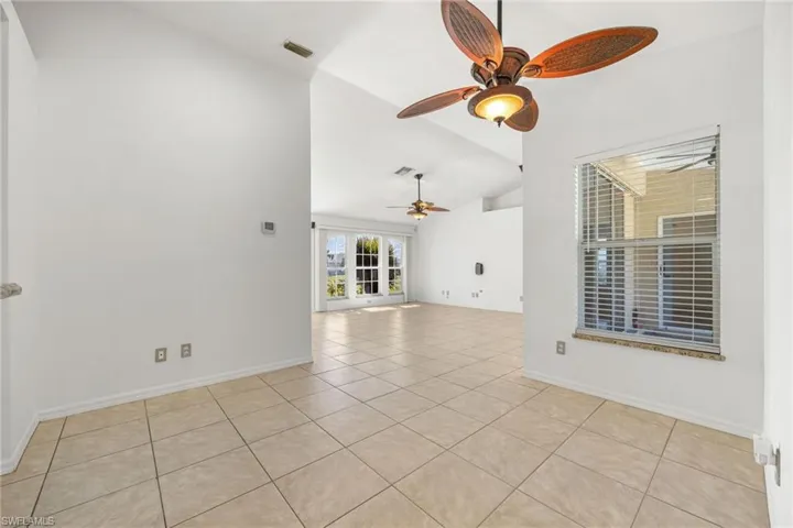 Spare room with light tile patterned floors and high vaulted ceiling