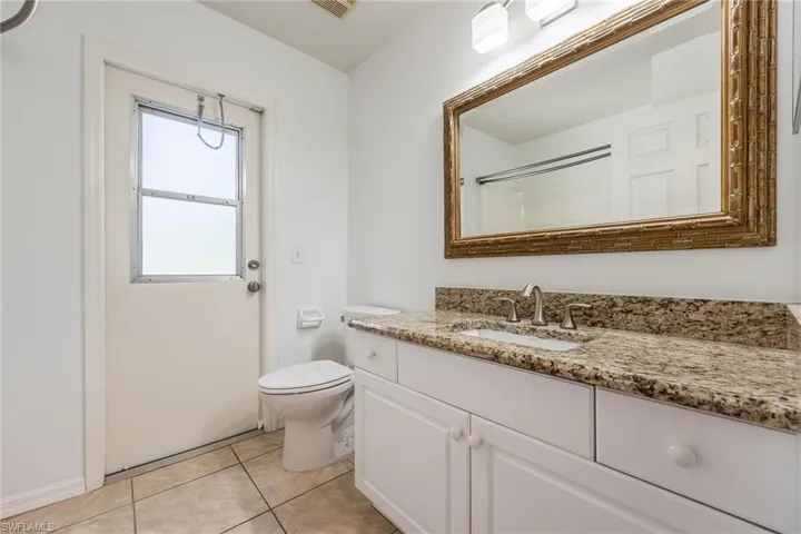 Full bath with vanity, light tile patterned floors, and a shower