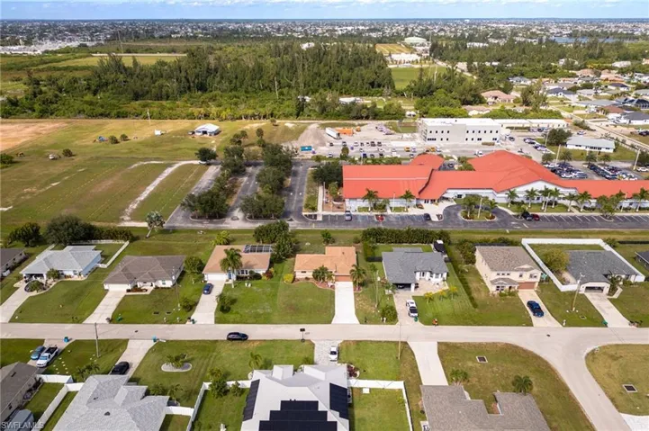 Aerial view of property and surrounding area with nearby suburban area