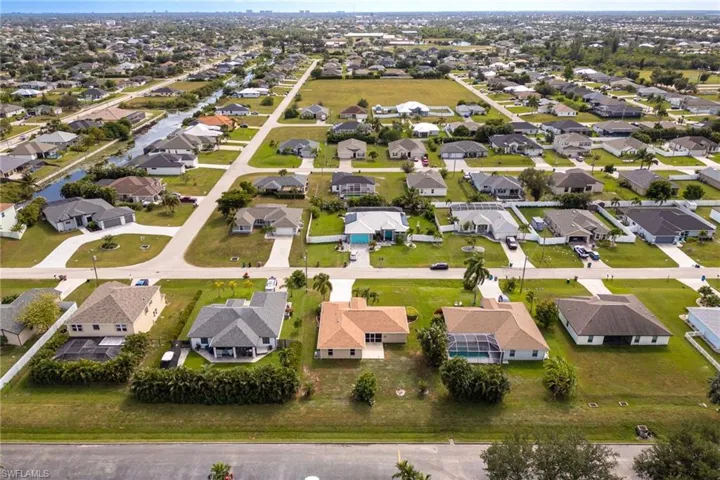 Aerial view of property's location with nearby suburban area and a nearby body of water