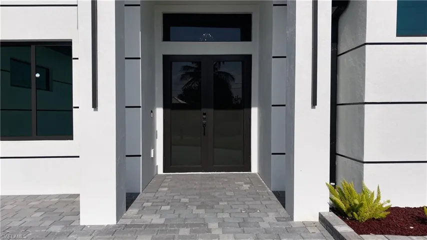 View of exterior entry featuring french doors and stucco siding