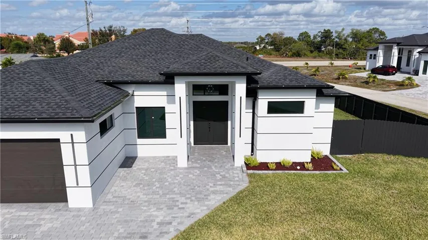 View of front of property with a shingled roof, an attached garage, decorative driveway, and stucco siding