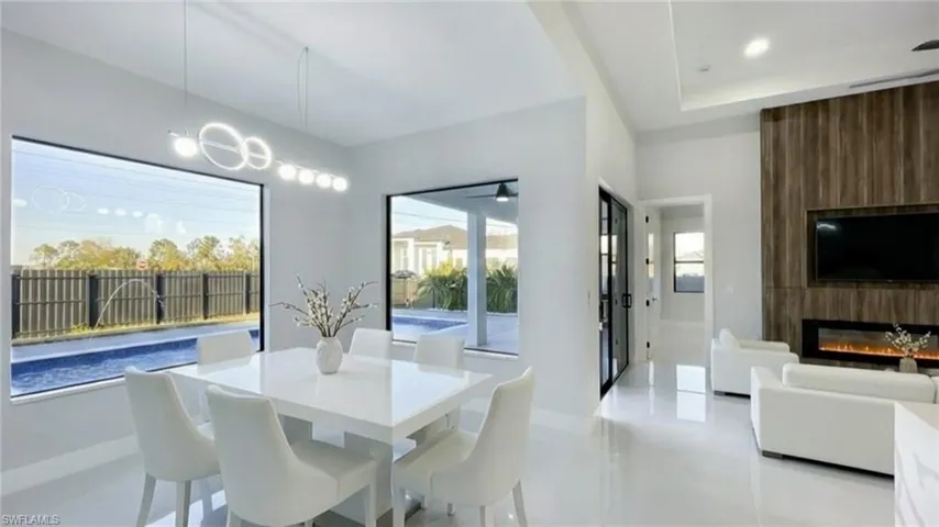 Dining room with a fireplace, recessed lighting, and a tray ceiling
