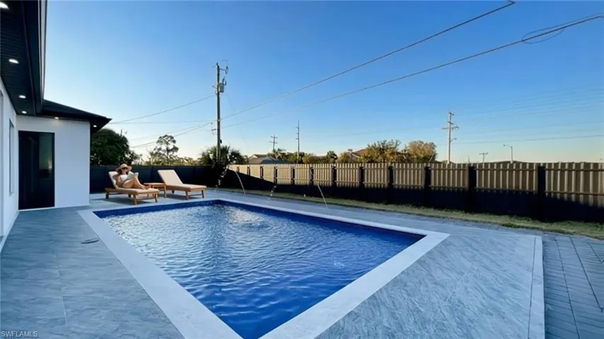 View of pool featuring a fenced backyard and patio surround