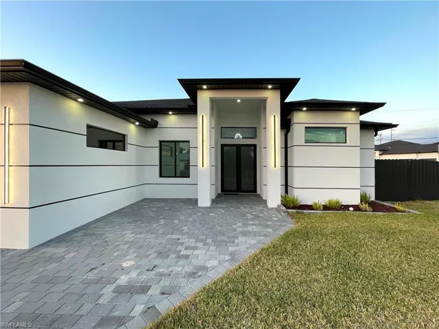 View of front of home featuring stucco siding and a patio area
