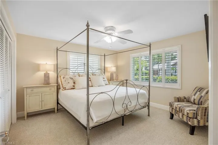 Bedroom featuring light carpet, ceiling fan, and a closet
