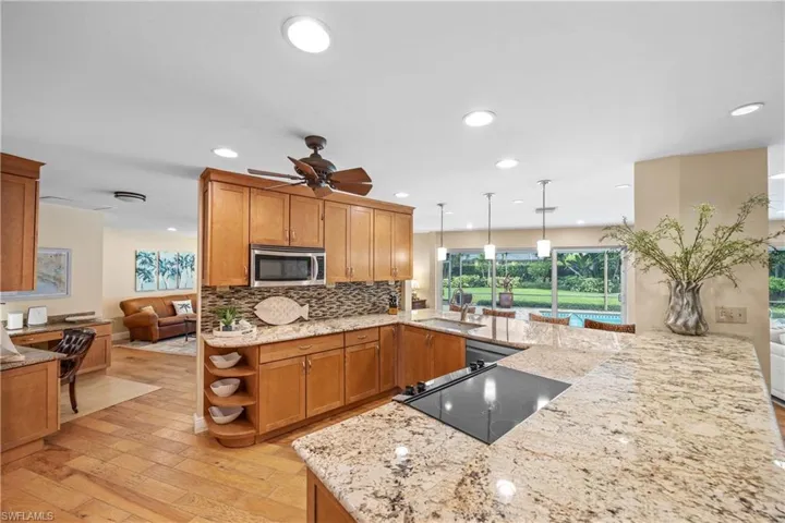 Kitchen featuring pendant lighting, tasteful backsplash, stainless steel appliances, sink, and ceiling fan