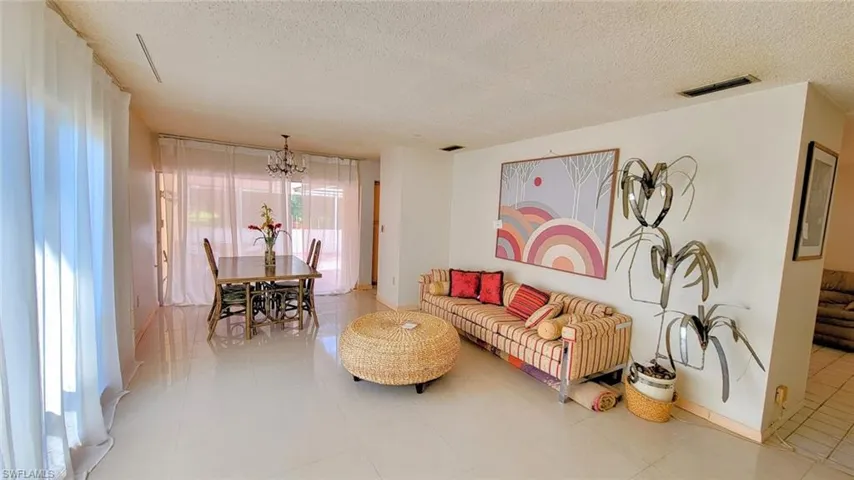 Tiled living room featuring a notable chandelier and a textured ceiling