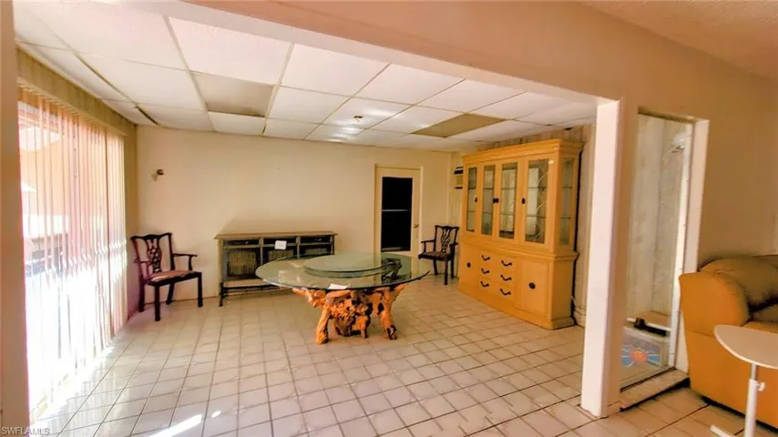 Dining room with plenty of natural light, light tile floors, and a drop ceiling