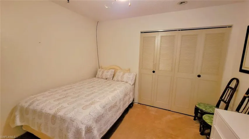 Bedroom featuring light carpet and a closet