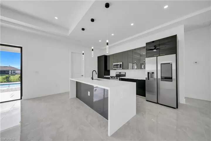 Kitchen featuring an island with sink, stainless steel appliances, modern cabinets, pendant lighting, and recessed lighting