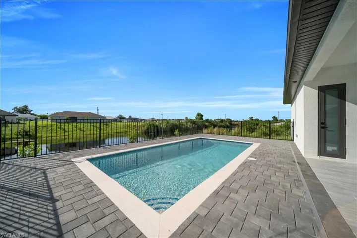 View of pool with a patio area and a water view