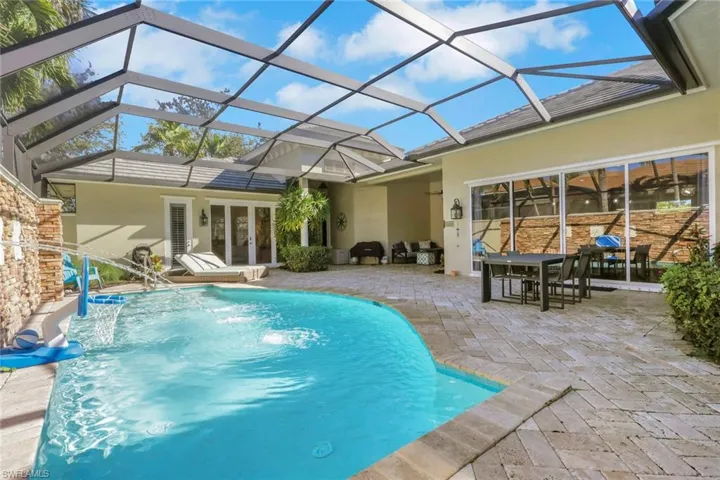Swimming pool with a patio area, a sunroom, glass enclosure, and french doors
