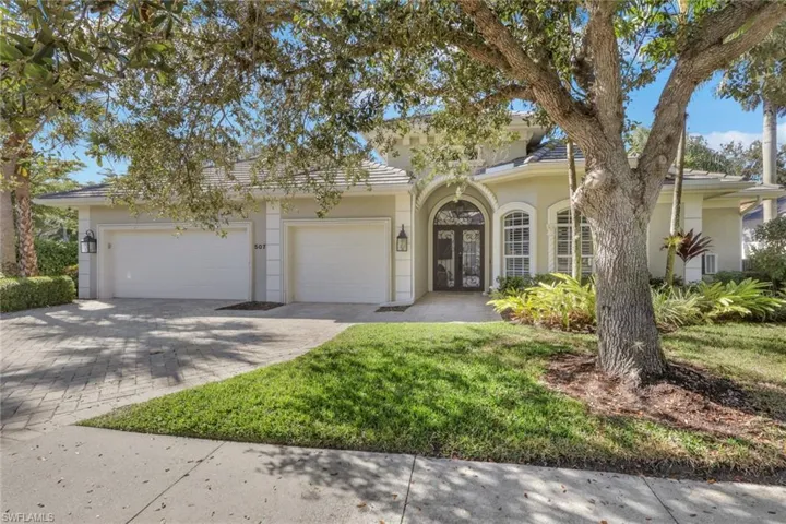 View of front facade featuring decorative driveway, stucco siding, a garage, and a front yard