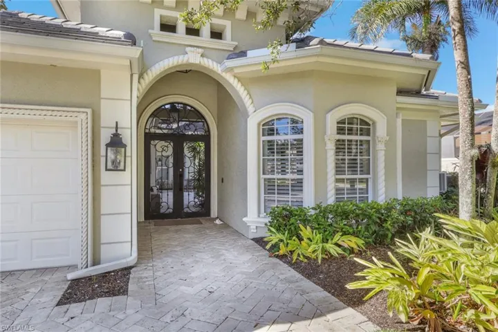 Property entrance featuring a tiled roof, stucco siding, and a garage