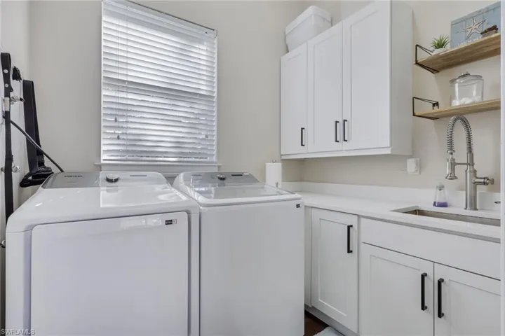 Washroom featuring washing machine and dryer and cabinet space