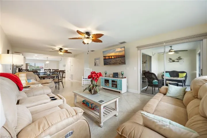 Living area featuring ceiling fan and tile patterned flooring