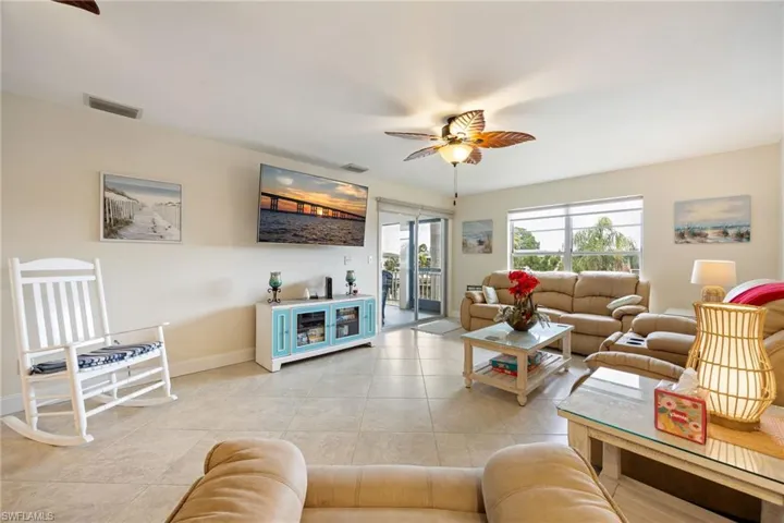 Living area with a ceiling fan and light tile patterned floors