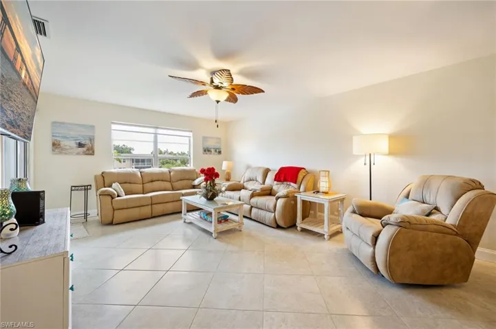 Living area featuring ceiling fan and light tile patterned floors