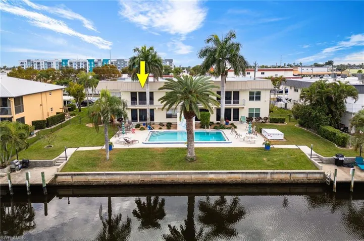 Back of property with a patio, a lawn, stucco siding, and a water view