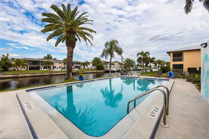 Community pool featuring a water view, a patio, and a residential view