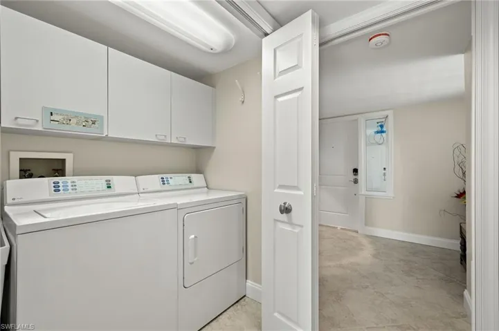 Washroom featuring cabinets and washer and dryer
