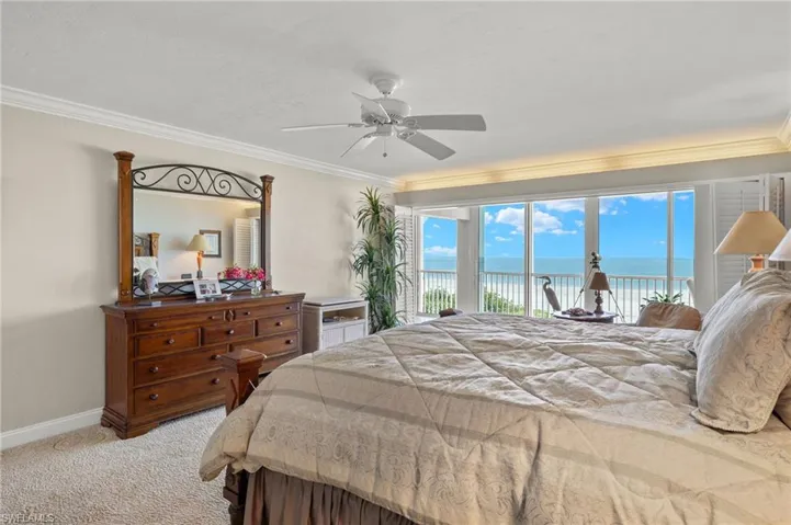 Carpeted bedroom with a water view, ceiling fan, access to outside, and crown molding